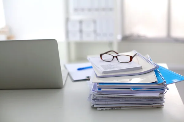 Beyaz arkaplanda dizin yığını olan dizüstü bilgisayar