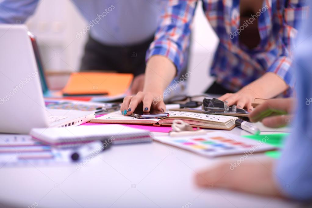 Close-up of three young creative designers working on project together. Team work