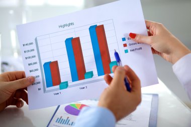 İş ortaklarının toplantıda belge ve fikirleri tartıştığı resim