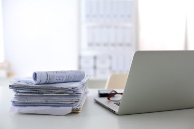 Beyaz arkaplanda dizin yığını olan dizüstü bilgisayar