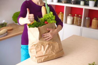 meyve ve sebze dolu alışveriş kese kağıdı tutan pozitif sağlıklı mutlu kadın