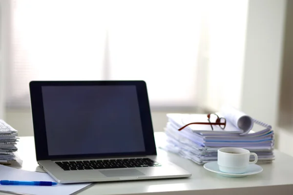 Ноутбук зі стосом тек на столі на білому тлі — стокове фото