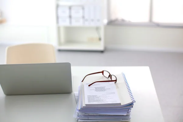 Beyaz arkaplanda dizin yığını olan dizüstü bilgisayar