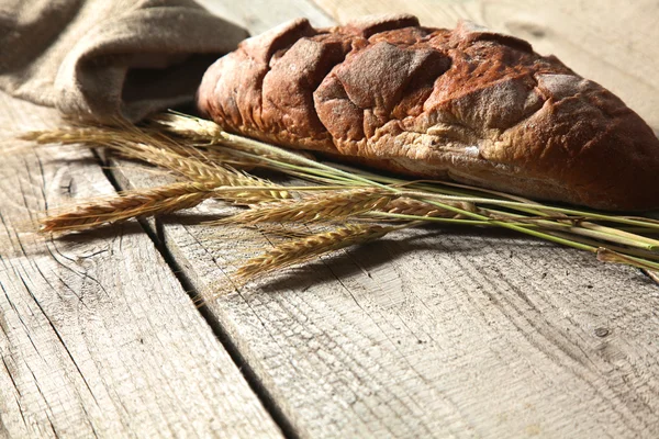 Freshly baked traditional bread on wooden table — Stock Photo, Image