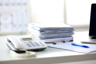 Beyaz arkaplanda dizin yığını olan dizüstü bilgisayar