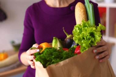 meyve ve sebze dolu alışveriş kese kağıdı tutan pozitif sağlıklı mutlu kadın