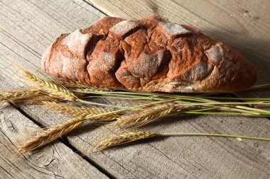 rustik kaşarlı ekmek ve buğday kulaklara koyu ahşap bir masa