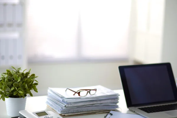 Laptop mit Ordnerstapel auf Tisch auf weißem Hintergrund — Stockfoto