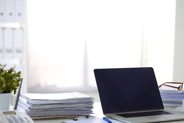 Laptop mit Ordnerstapel auf Tisch auf weißem Hintergrund — Stockfoto