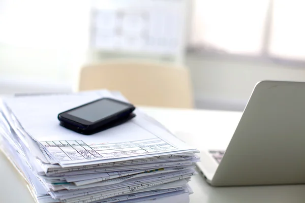 Ordinateur portable avec pile de dossiers sur la table sur fond blanc — Photo