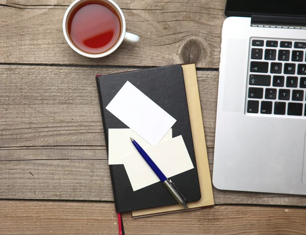 Lege visitekaartjes met pen, laptop en thee cup op houten office tabel — Stockfoto