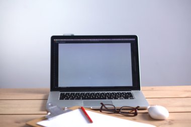 Laptop ahşap bir masada duruyor.