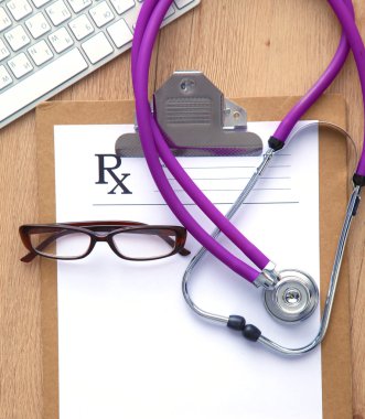 Beyaz ahşap bir masa üstünde a laptop yanında sağlık stetoskop