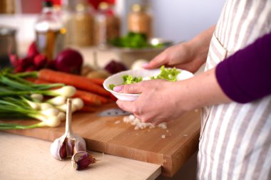 Genç kadın mutfakta yemek pişiriyor. Sağlıklı Yemek