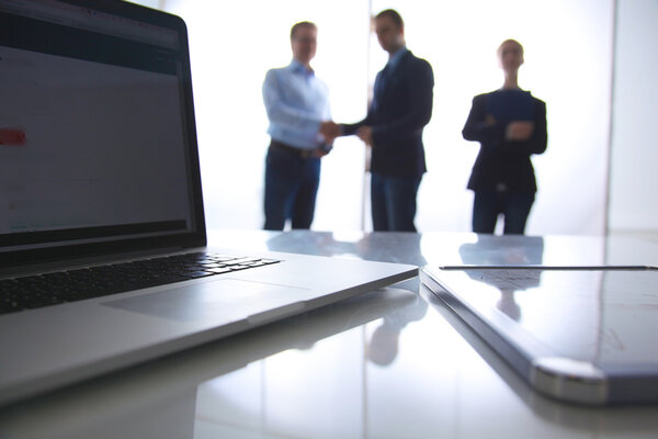 Сосредоточься на ноутбуке. Размытые люди на заднем плане
