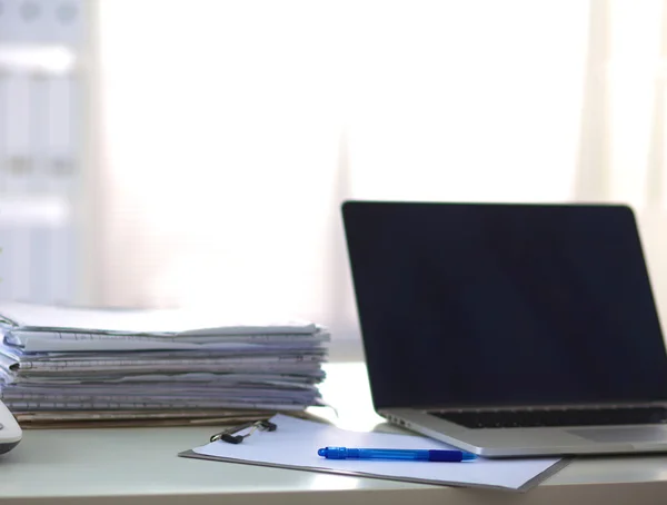 Laptop met stapel mappen op tafel op witte achtergrond — Stockfoto