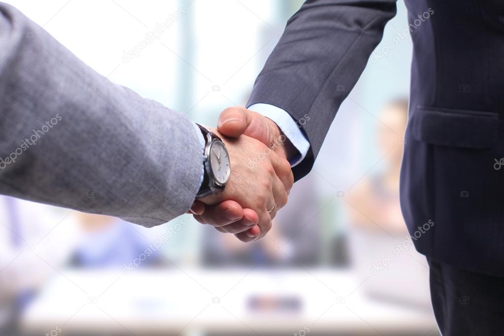 Business handshake. Two businessman shaking hands with each other in the office