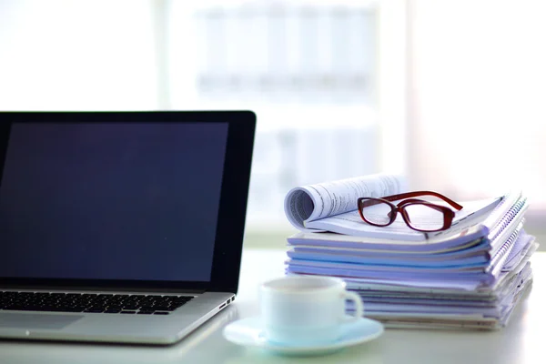 Laptop met stapel mappen op tafel op witte achtergrond — Stockfoto