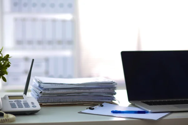 Laptop mit Ordnerstapel auf Tisch auf weißem Hintergrund — Stockfoto