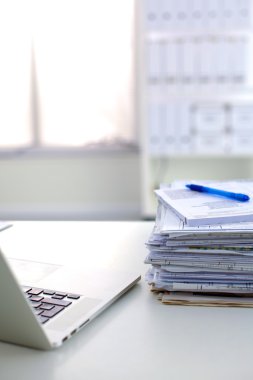 Beyaz arkaplanda dizin yığını olan dizüstü bilgisayar