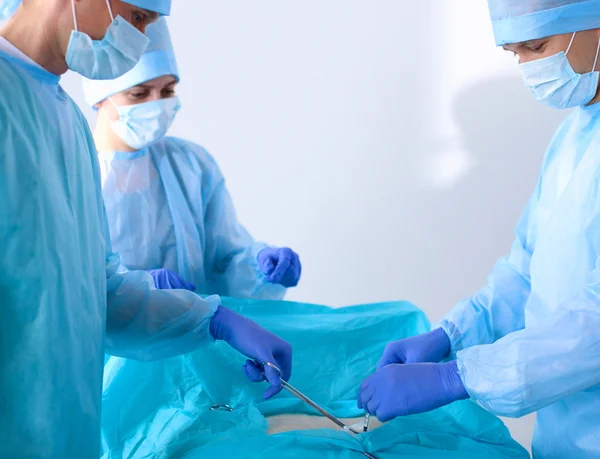 Une équipe de chirurgiens en uniforme opère un patient à la clinique de chirurgie cardiaque — Photo