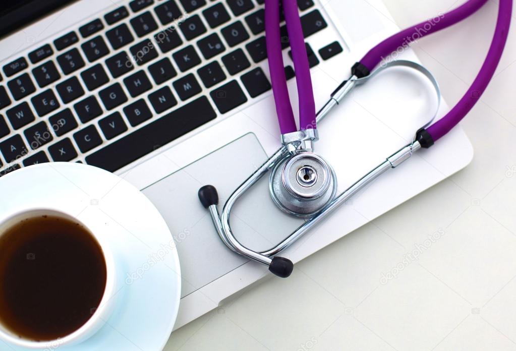 Medical stethoscope and laptop on the table