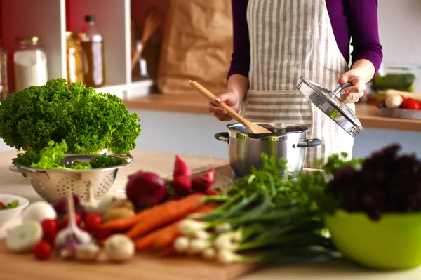 Jovem mulher cortando legumes na cozinha — Fotografia de Stock