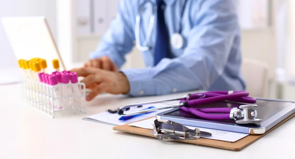 Médico médico sentado en la mesa y mirando pacientes roentgen — Foto de Stock