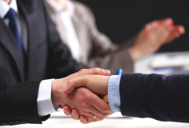 İş adamları iş toplantısında, ofiste oturup tartışıyorlar.