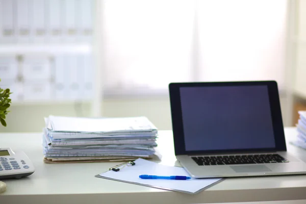 Laptop mit Ordnerstapel auf Tisch auf weißem Hintergrund — Stockfoto