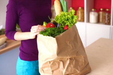 meyve ve sebze dolu alışveriş kese kağıdı tutan pozitif sağlıklı mutlu kadın