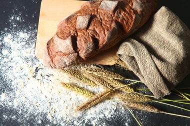 rustik kaşarlı ekmek ve buğday kulaklara koyu ahşap bir masa