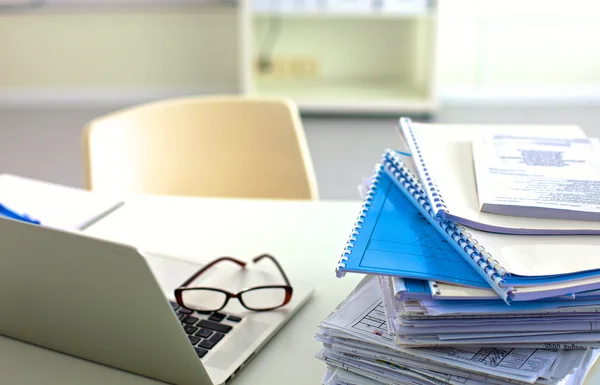 En bunt med papper på skrivbord med en dator — Stockfoto