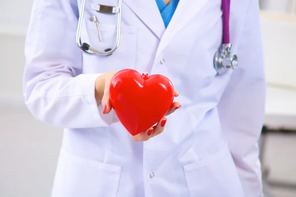 Medic cu stetoscop care examinează inima roșie — Fotografie, imagine de stoc