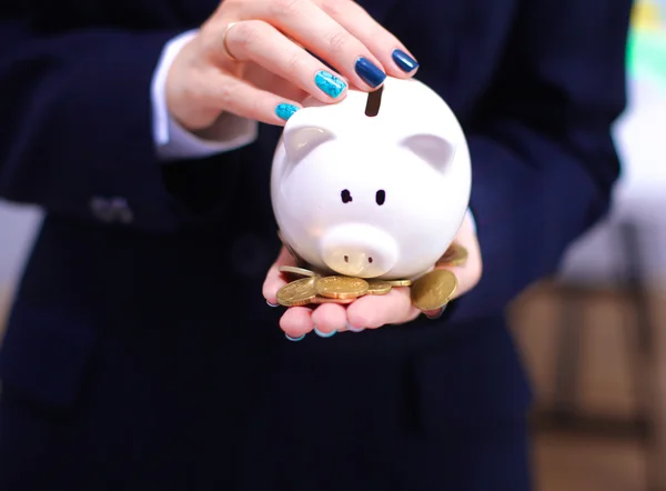 Jonge mooie vrouw met piggy bank, geïsoleerd op witte achtergrond — Stockfoto