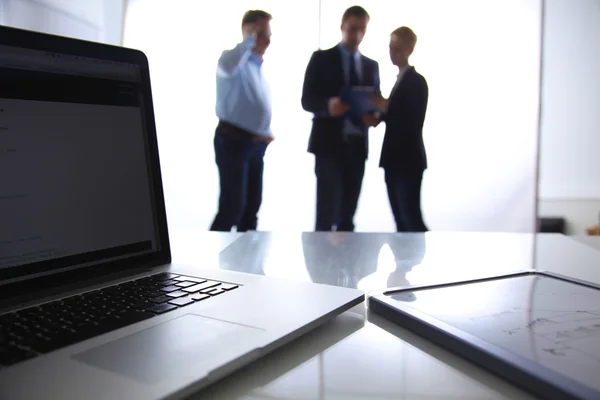 Focus op laptop op de tafel. Wazig mensen op achtergrond — Stockfoto