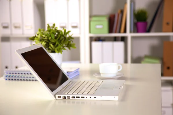 有台手提电脑，一杯咖啡和白色的窗帘，在阳光明媚的一天的工作桌室内的近视图 — 图库照片