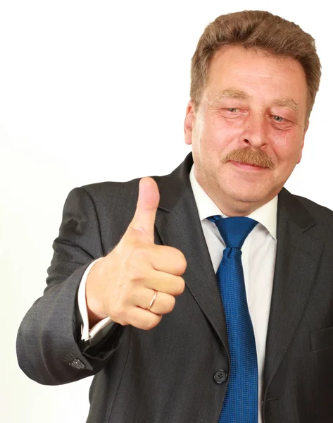 Happy affärsman visar tummen och ler medan hans kollegor står i bakgrunden — Stockfoto