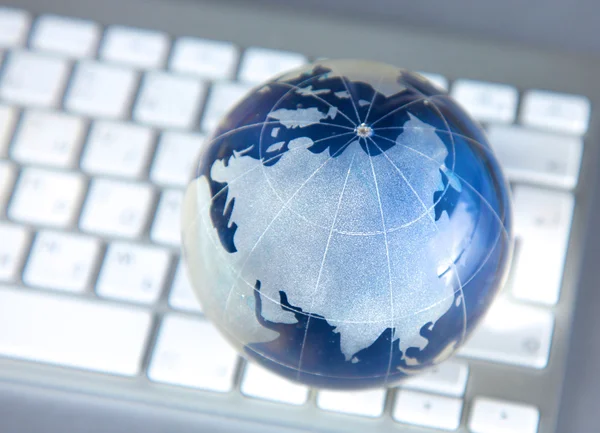 Cristal globe de la Terre sur un ordinateur — Photo