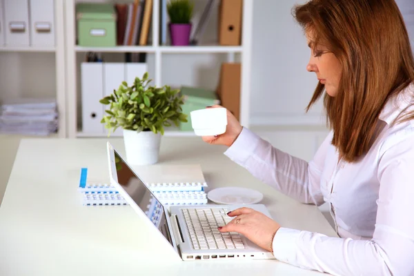 Junge Geschäftsfrau arbeitet an einem Laptop — Stockfoto