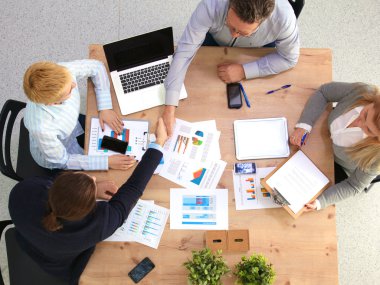 İş ortaklarının toplantıda belge ve fikirleri tartıştığı resim