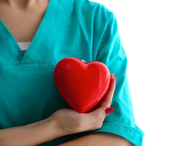 Mujer joven doctora sosteniendo un corazón rojo, en el consultorio — Foto de Stock