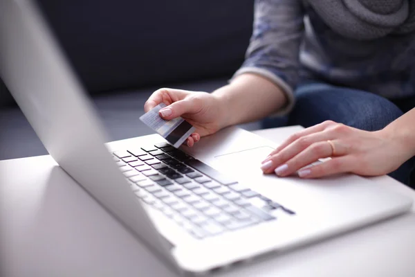 Frau sitzt am Schreibtisch, kauft mit Laptop und Kreditkarte ein — Stockfoto