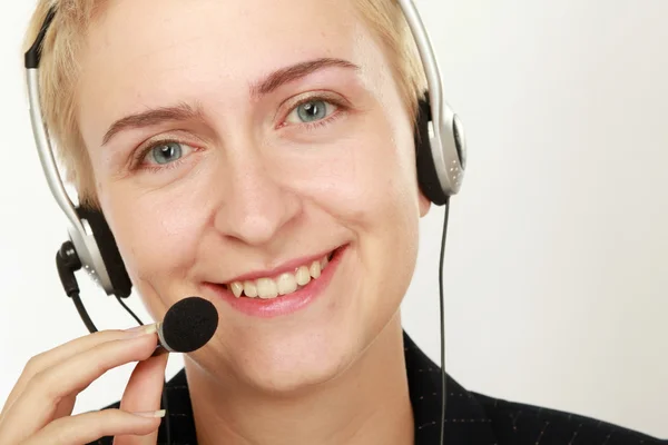 Operadora de centro de llamadas femenino con auriculares navegando en su computadora — Foto de Stock