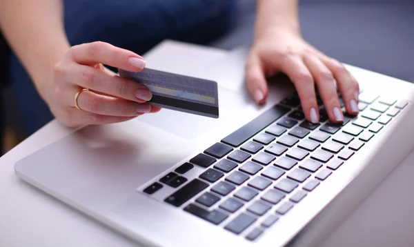 Mujer sentada en el escritorio, comprando con laptop y tarjeta de crédito — Foto de Stock