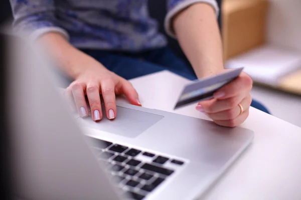 Femme assise au bureau, magasinage avec ordinateur portable et carte de crédit — Photo