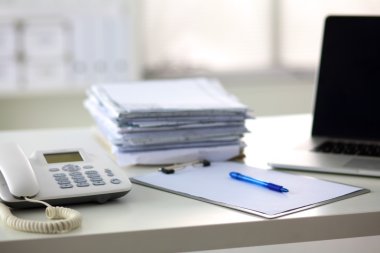 Beyaz arkaplanda dizin yığını olan dizüstü bilgisayar