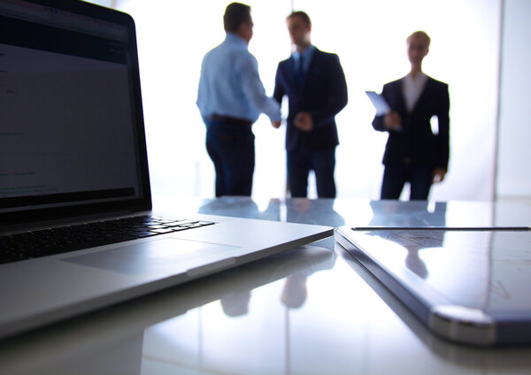 Сосредоточься на ноутбуке. Размытые люди на заднем плане
