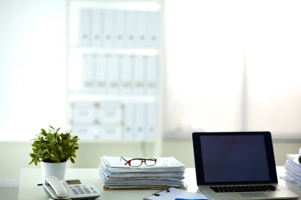 Laptop mit Ordnerstapel auf Tisch auf weißem Hintergrund — Stockfoto