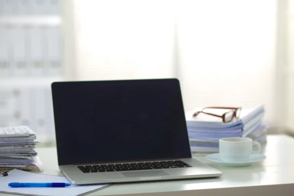 Laptop med stapel av mappar på bordet på vit bakgrund — Stockfoto